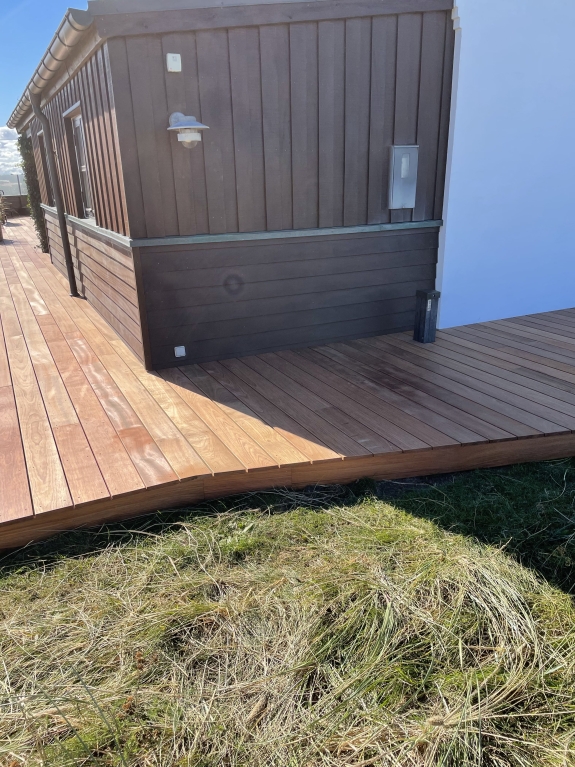 Hjørne af træterrasse ved husets facade
