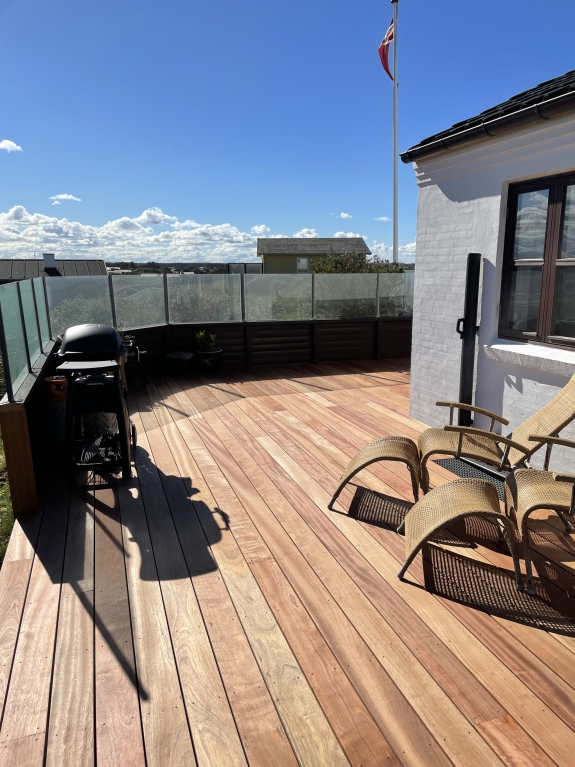 Træterrasse med glasafskærmning og sollys