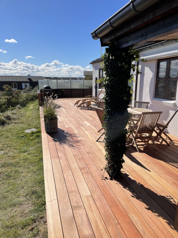 Træterrasse med grill og loungestole