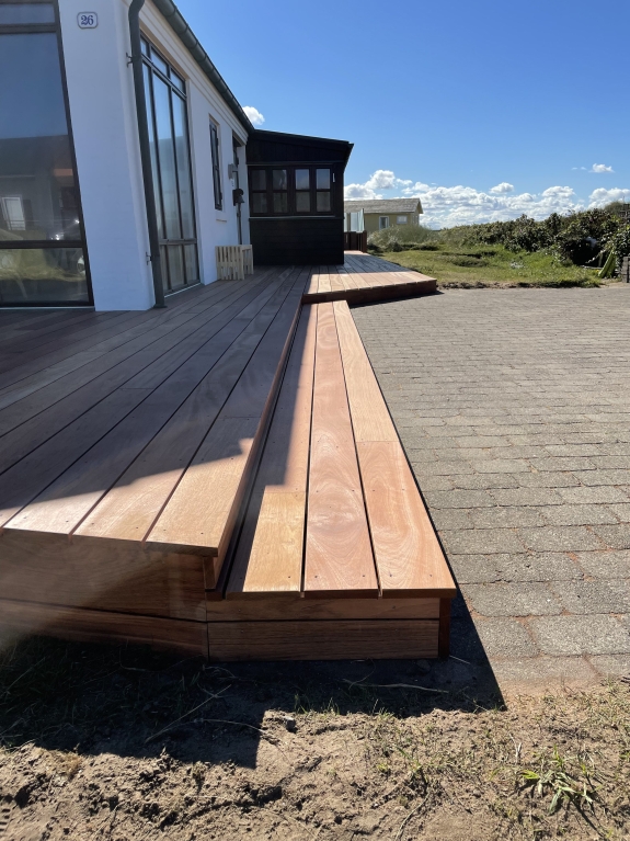 Træterrasse med niveauer og belægning i baggrunden